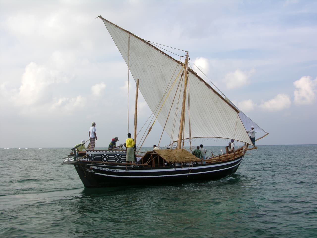 Traditional Lakshadweep sailing dhow with white lateen sail crossing the Arabian Sea
