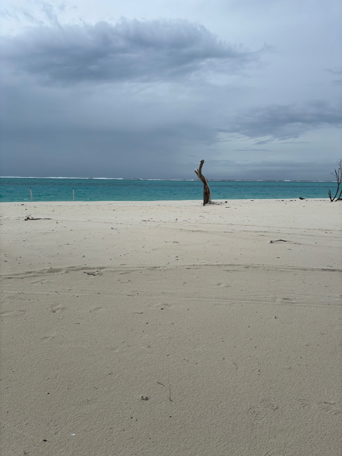 Lakshadweep beach and turquoise lagoon under a cloudy sky
